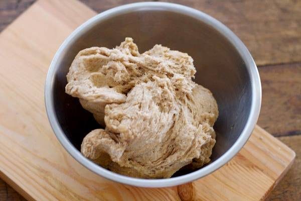 Whole wheat pizza dough in a mixing bowl.