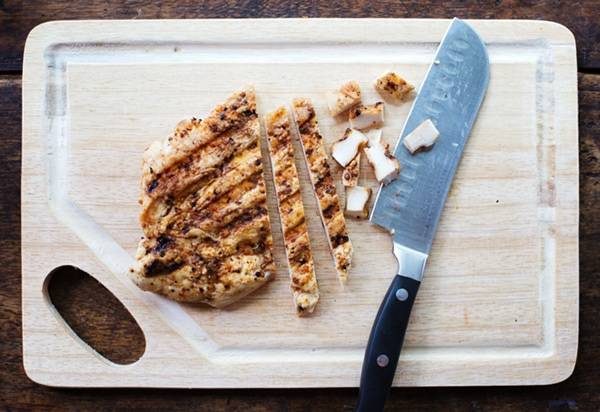 Grilled chicken sliced on a cutting board.