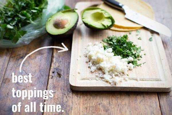 Cheese and herbs on a cutting board.