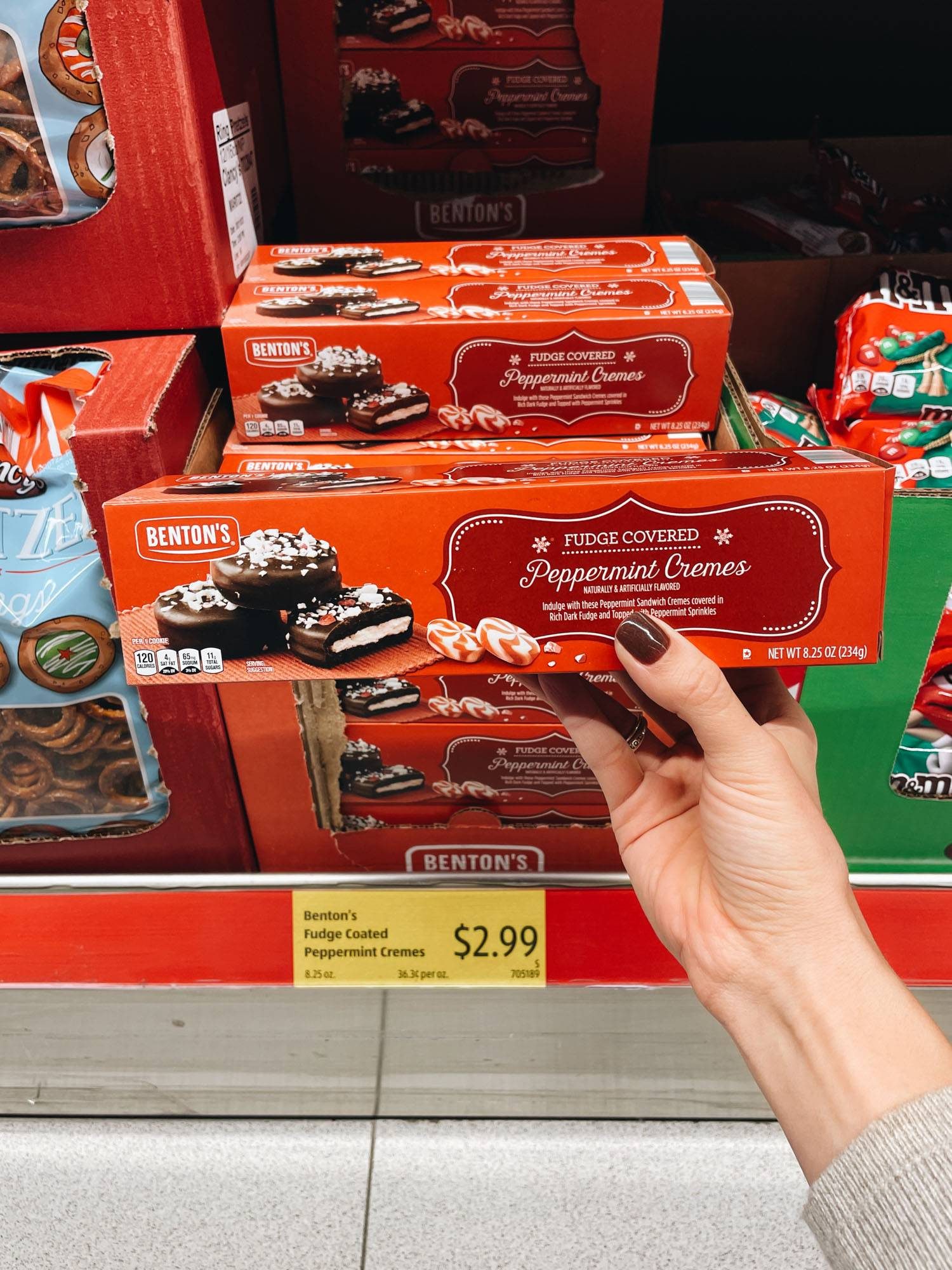 White hand holding box of chocolate cookies