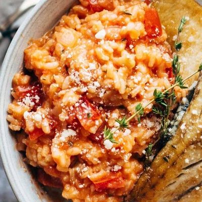 Barrumundi fish with tomato risotto on a plate.