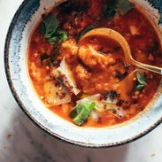 Spoon in bowl of tomato and bread soup