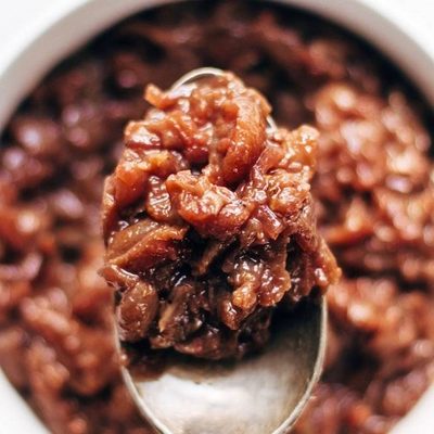 Caramelized Shallot and Grape Chutney in a jar with spoon.