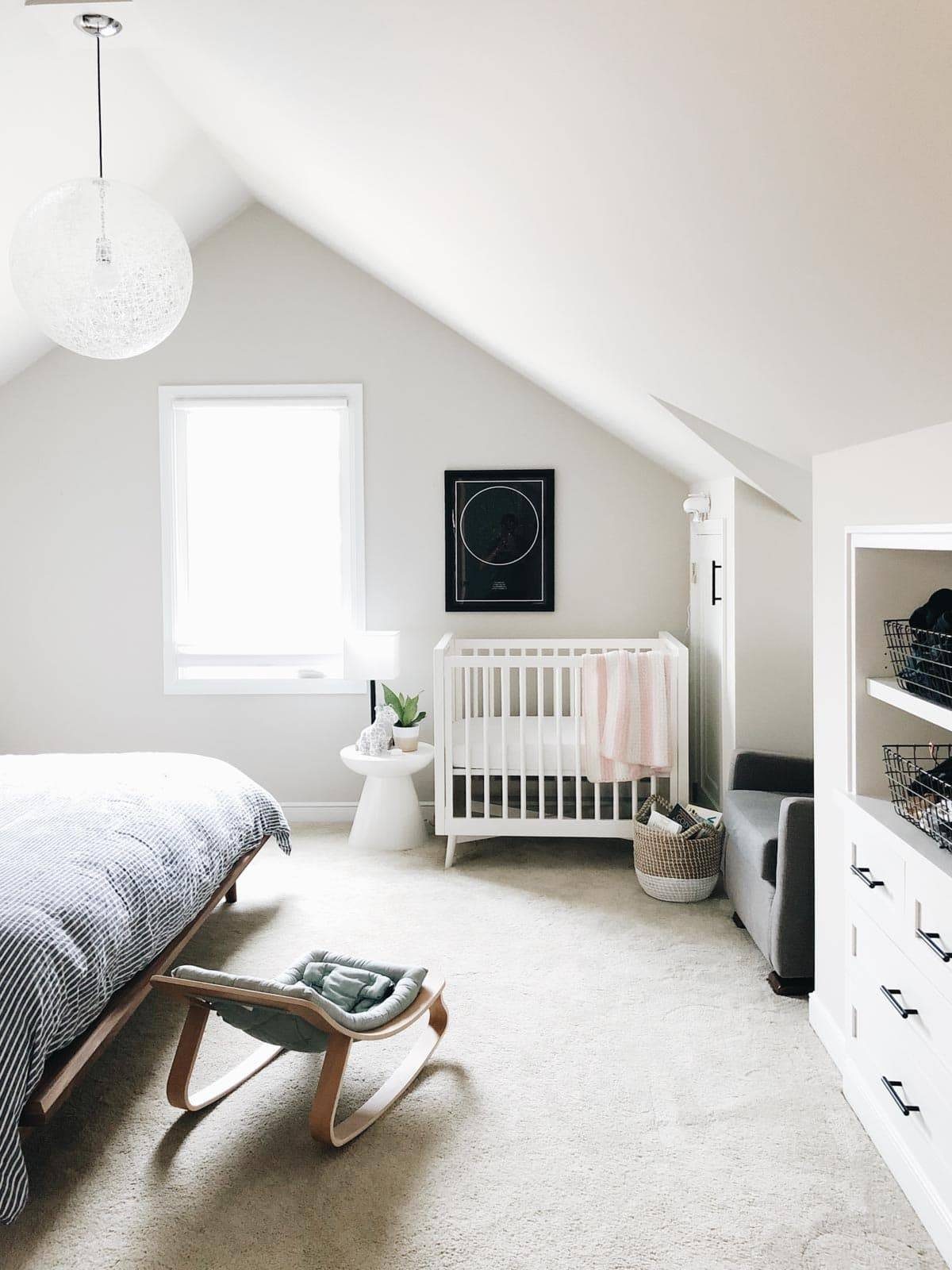 An attic bedroom with a bed, crib and furniture.