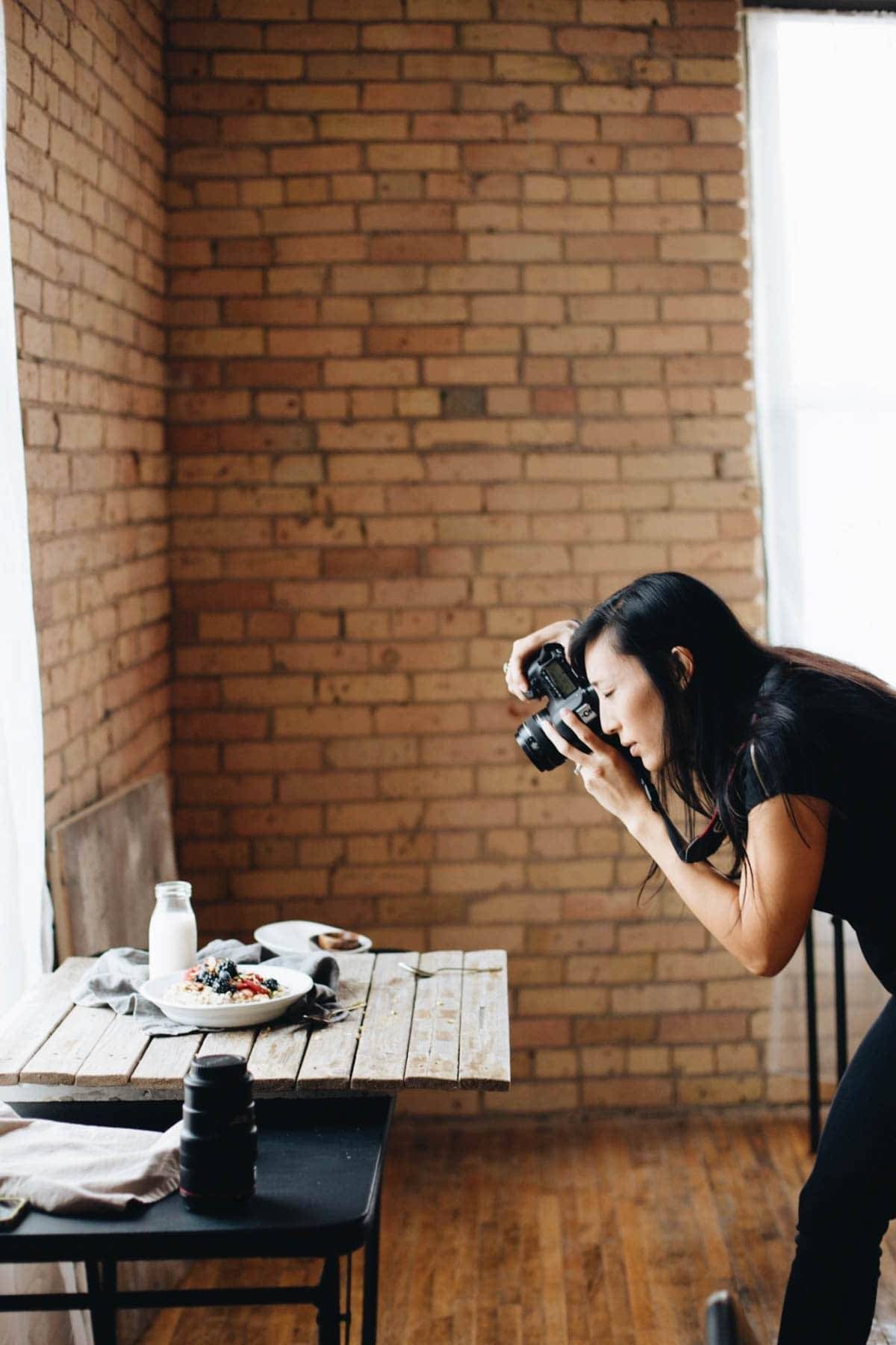 Woman taking a photo of a plate of food.
