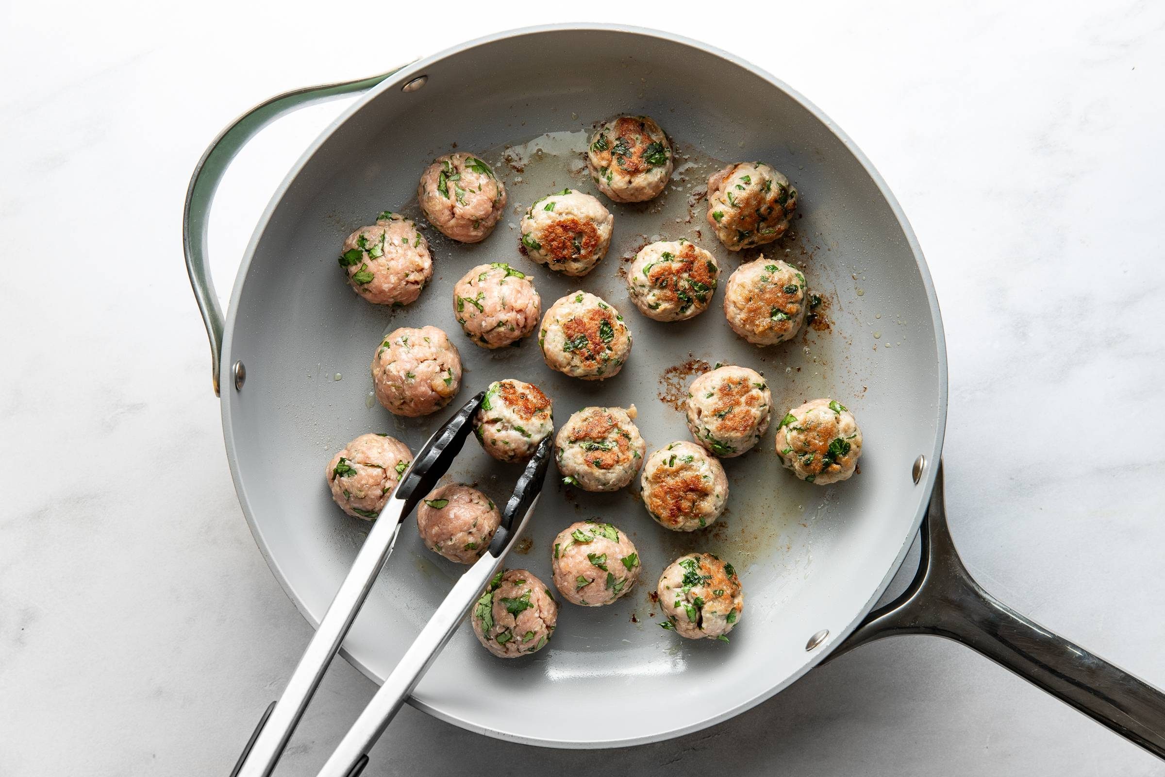 Cooking meatballs in a skillet.